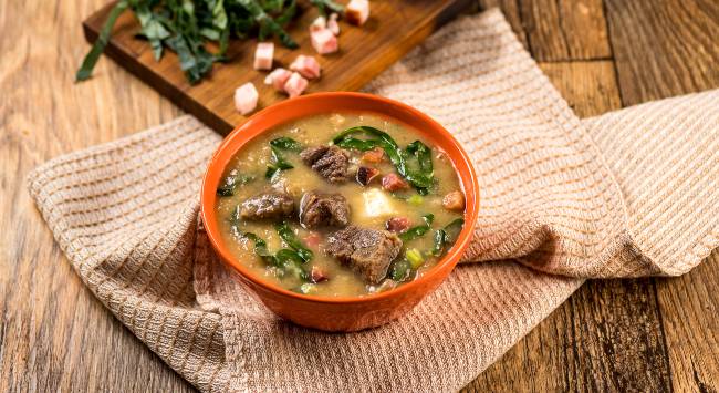 Creme proteico feito com mandioca e servido costela, bacon e couve.