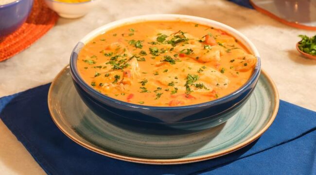 Moqueca de tilápia servida em pote redondo azul e branco
